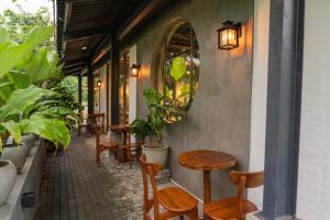 a patio with tables and chairs and a mirror at Ankola Hotel in Homagama