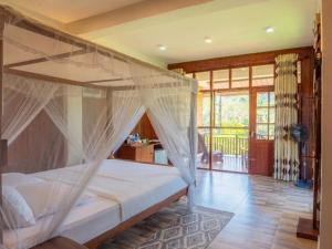 a bedroom with a bed with mosquito net at Hotel Levon Ella in Ella