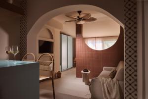 a kitchen with a ceiling fan and a living room at Shellona Rooms & Apartments in Laganas
