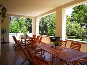 a dining room with tables and chairs and large windows at Villa Ramolina - Metaponto in Metaponto