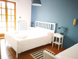 a bedroom with a white bed and a blue wall at Villa Ramolina - Metaponto in Metaponto +35 photos