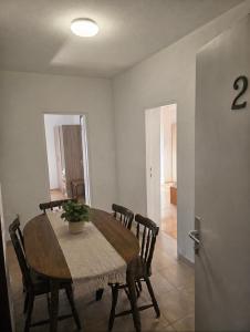 a dining room with a wooden table and chairs at Apartmani Kasteljan 2, Stara Novalja in Stara Novalja