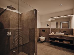 a bathroom with a shower and a toilet and a sink at Lechthaler Apartments in Resia +69 photos