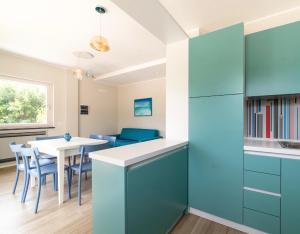 a kitchen with blue cabinets and a table with chairs at Micabalù Luxury Apartment in Marina di Camerota