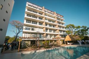 a hotel with a swimming pool in front of a building at Pacific Surfside Ocean Views in Surf City in ChiltiupÃ¡n