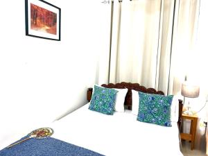 a bedroom with a bed with blue and white pillows at The cosy corner in Zanzibar City