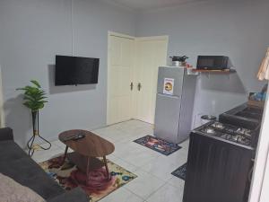 a kitchen with a refrigerator and a table in a room at Zara Appartement in Paramaribo