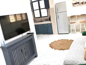 a living room with a flat screen tv on a stand at The cosy corner in Zanzibar City +12 photos