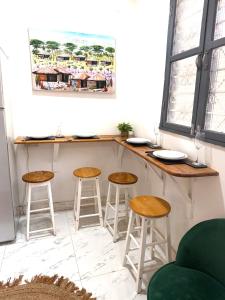 a bar with three stools and a counter in a room at The cosy corner in Zanzibar City