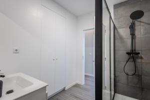 a white bathroom with a shower and a sink at Azor Signature Flats - I in Ponta Delgada +40 photos