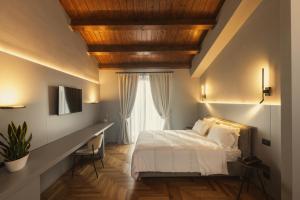 a bedroom with a bed and a desk with a window at Masseria Pietrafitta in Foggia +3 photos