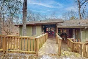 a small green house with a wooden deck at The Loblolly in Bella Vista