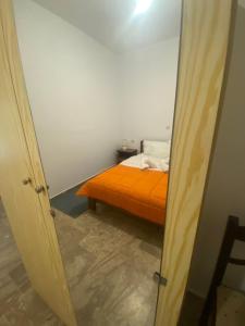 a bedroom with an orange bed in a room at Apartments MOYRKOS in Missolonghi