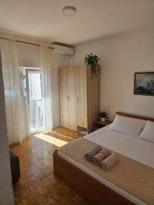 a bedroom with a large bed and a large window at Apartmani Kasteljan 2, Stara Novalja in Stara Novalja