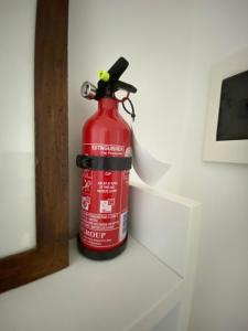 a fire extinguisher is sitting on a wall at Renaio House Buti in Bientina +25 photos