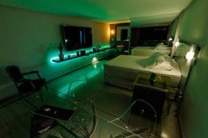 a room with two beds in a room with green lights at Lemon Motel- Afogados in Recife