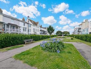 a park with a bench and flowers in the grass at Steyne by the Sea in Bognor Regis
