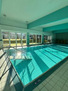 a large swimming pool in a building at Grubhof Schlosspark, Chalet-Stil mit Pool und Bergblick - Air Conditioner in Sankt Martin bei Lofer