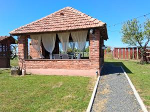 a brick pavilion with a table and chairs in a yard at Kuca za odmor Noel in Sveti Ivan Žabno