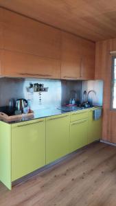 a kitchen with yellow cabinets and a sink at CHIC Riverfront Retreat with Private Jacuzzi, BIG BERRY in Gradac