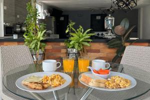 two plates of food on a glass table with drinks at Hotel Palmas del Estadio in Medellín