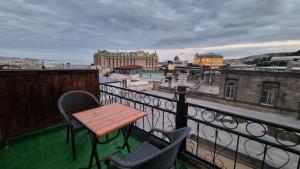 a table and chairs on a balcony with a view at Grand Hotel 1902 in Baku