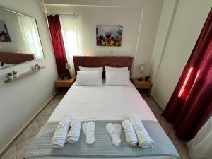 a bedroom with a bed with two pairs of white slippers at Windmill view apartment in Antimácheia +33 photos