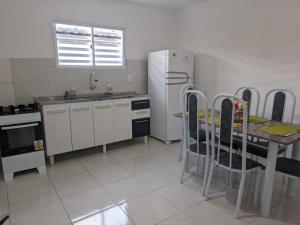 a kitchen with a table and a refrigerator at Well-located house for seasonal rental in Bananeiras. in Bananeiras +7 photos
