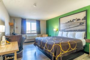 a hotel room with a bed and a desk at Super 8 by Wyndham Sioux City South in Sioux City