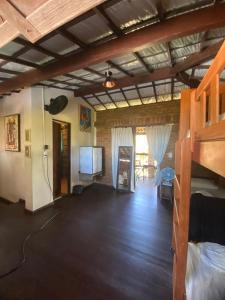 a living room with a bunk bed and a television at Hostel do Ceu in Pipa
