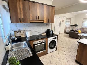 a kitchen with a sink and a washing machine at Windmill view apartment in Antimácheia