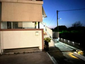 a white building with a plant on the side of it at Windmill view apartment in Antimácheia
