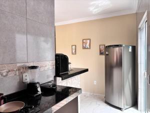 a kitchen with a stainless steel refrigerator at Casa das Petúnias in Ubajara