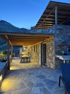 an outdoor patio with a wooden pergola at To Petrino Serifos in Livadakia