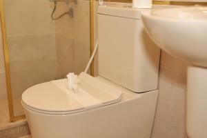 a white bathroom with a toilet and a sink at Royal Town Hotel in Cairo +37 photos