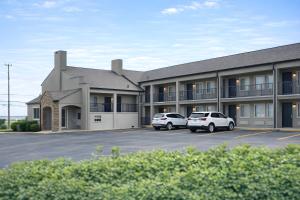a building with two cars parked in a parking lot at Quarters Inn & Suites in Antioch