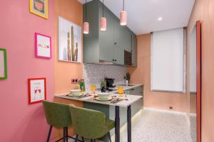 a kitchen with pink walls and a table with chairs at La Casa Mexicana in Alfortville +12 photos