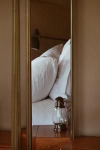 a reflection of a bed with white pillows in a mirror at Fazenda Azul in Budens
