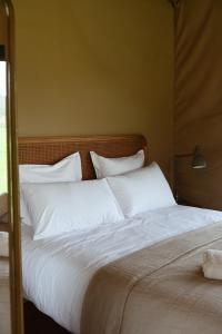 a large bed with white sheets and pillows at Fazenda Azul in Budens