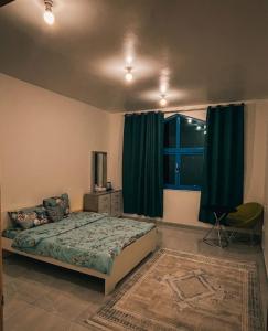 a bedroom with a bed and a window with green curtains at Vi Home Stay Corniche in Abu Dhabi