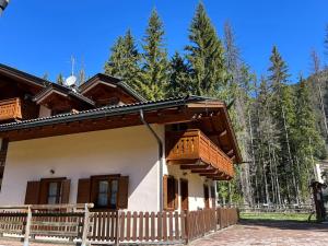a house with a wooden fence in front of it at Cèsa Aurora in Canazei