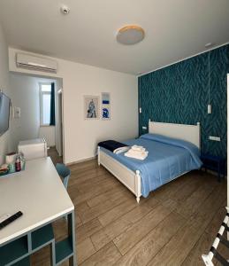 a bedroom with a bed and a desk in it at Molo '93 - RoomsAndSea in Belvedere Marittimo