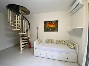 a white room with a bed and a staircase at La mia casetta in Taormina