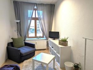 a living room with a chair and a tv at Grosses Zimmer im Zentrum Elise , ruhig & gemuetlich in Chemnitz