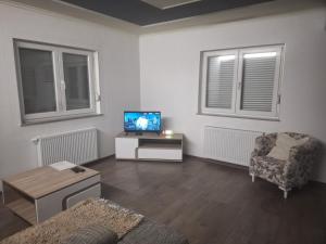 a living room with a tv and a chair at Apartman Knežević in Donja Varoš