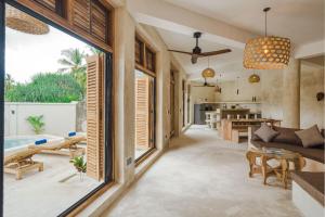 a living room with a large window and a living room with a couch at Nishati - Private Beach Villa in Matemwe