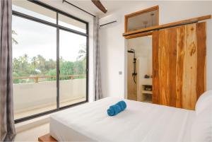 a bedroom with a bed and a large window at Nishati - Private Beach Villa in Matemwe