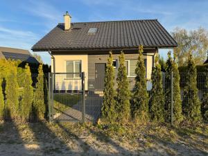 a fence in front of a small house at Domek in Kamień Pomorski
