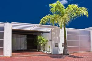 a palm tree in front of a garage at Lemon Motel- Piedade in Recife