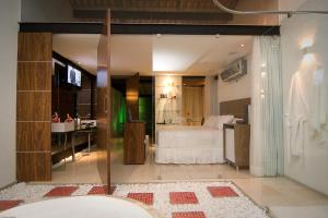 a bathroom with a bed and a tub in a room at Lemon Motel- Piedade in Recife